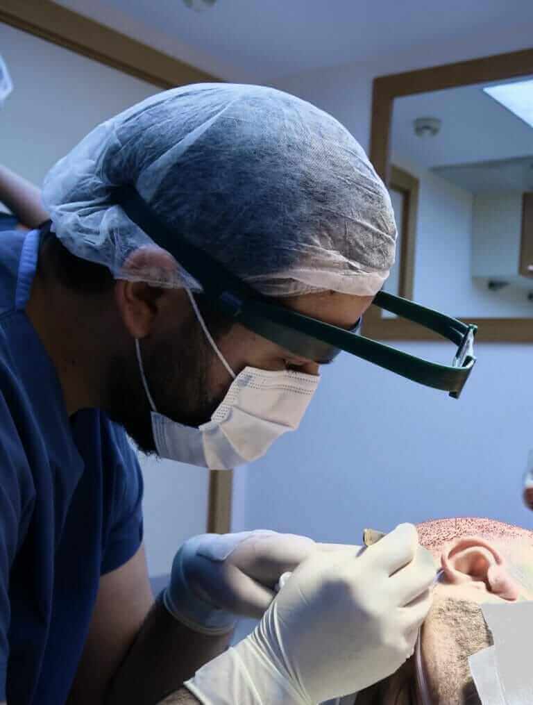 Dr. Utkan during a hair transplant surgery.